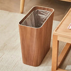 Wooden trash bin with a metallic liner on a carpeted floor.