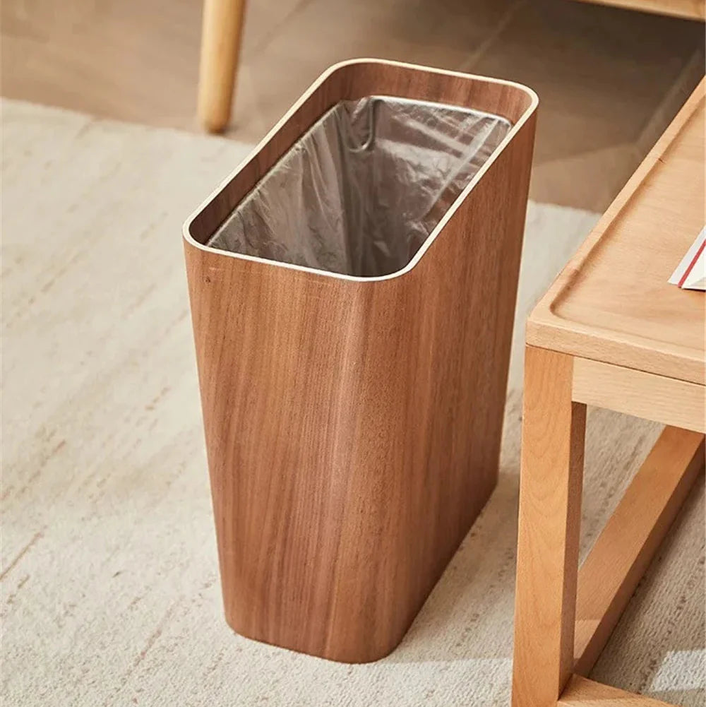 Wooden trash bin with a metallic liner on a carpeted floor.