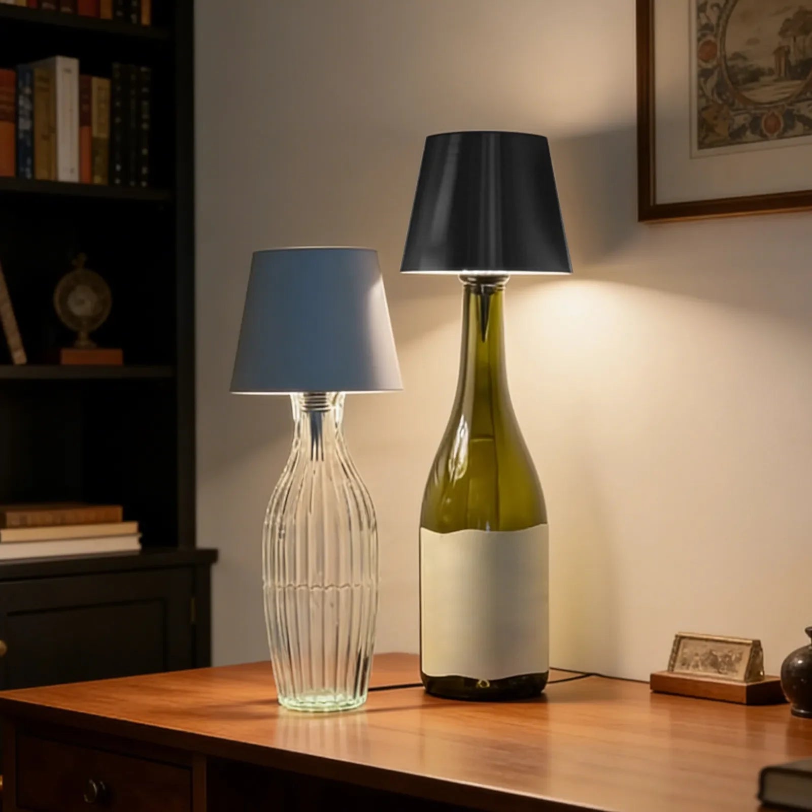 Two table lamps, one made from a clear glass bottle and the other from a green wine bottle, on a wooden surface.