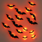 A set of black plastic bat wall decals or decorations arranged on a plain background, each glowing with a warm orange light from within.