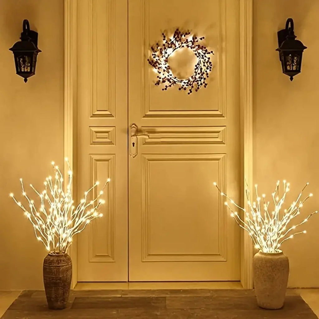 Decorative wreath and LED branches on a door with warm lighting