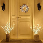 Decorative wreath and LED branches on a door with warm lighting