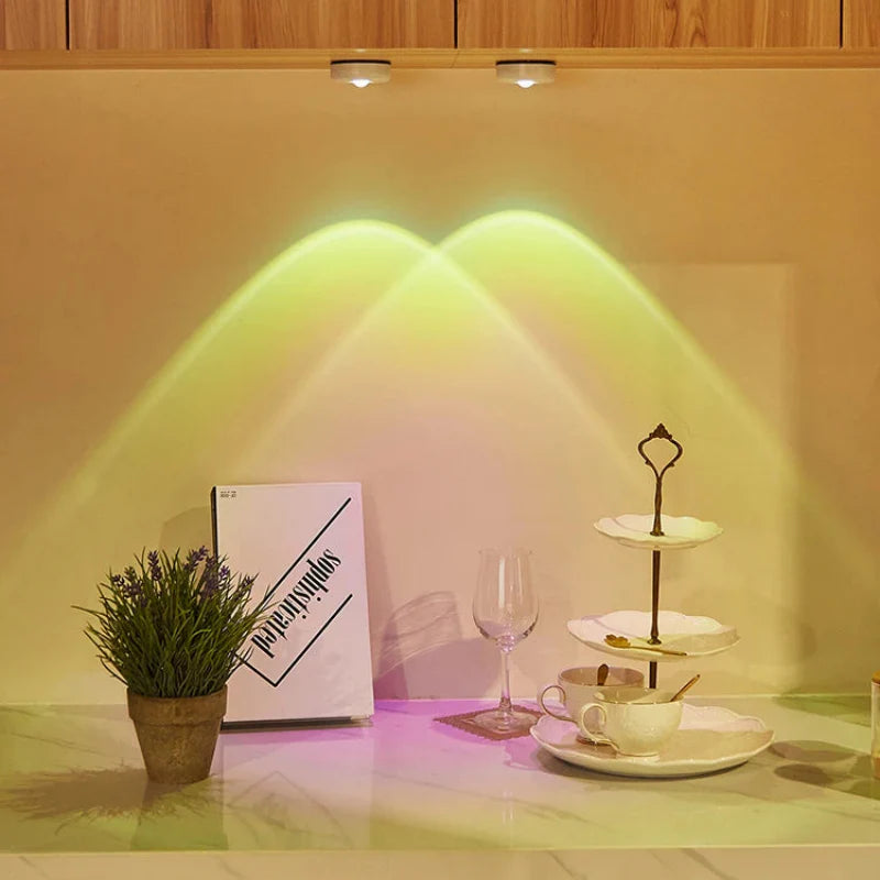 Decorative setup with a plant, book, glass, and tea set on a countertop with warm lighting.