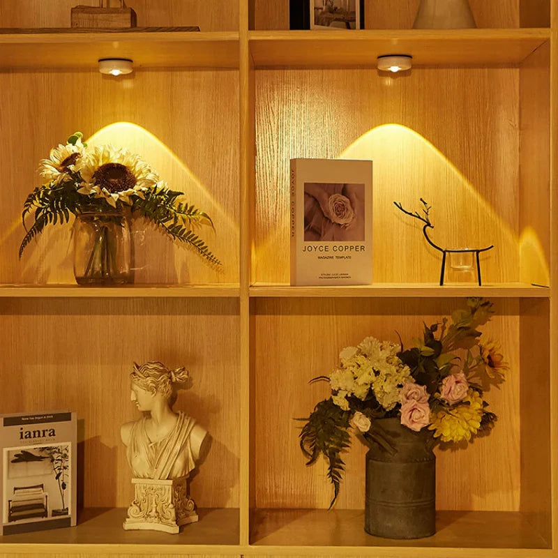 Wooden shelf with decorative items including a bust, flowers, and books.