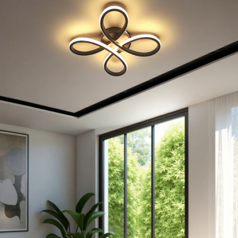 Modern ceiling light fixture in a room with a large window and plant