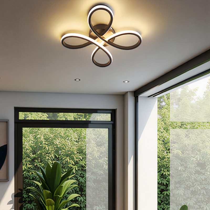 Modern ceiling light fixture in a room with large windows and greenery outside