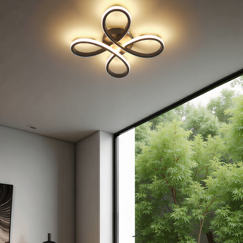 Modern ceiling light fixture in a room with a large window showing greenery outside.