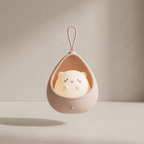 Cute animal-shaped night light in a pink holder on a neutral background