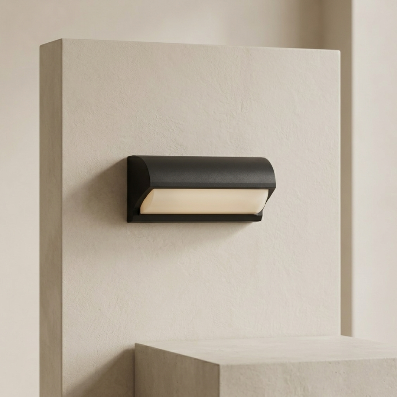 Modern black wall-mounted light fixture on a neutral wall.