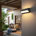 Outdoor wall light fixture on a house exterior with a patio in the background