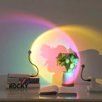 Colorful light projection on a wall with books and a plant in the foreground.