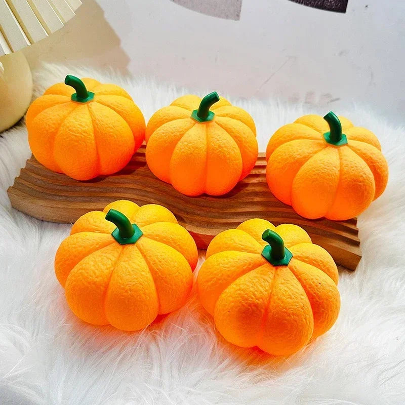 Five orange pumpkins with green stems on a wooden stand against a white background