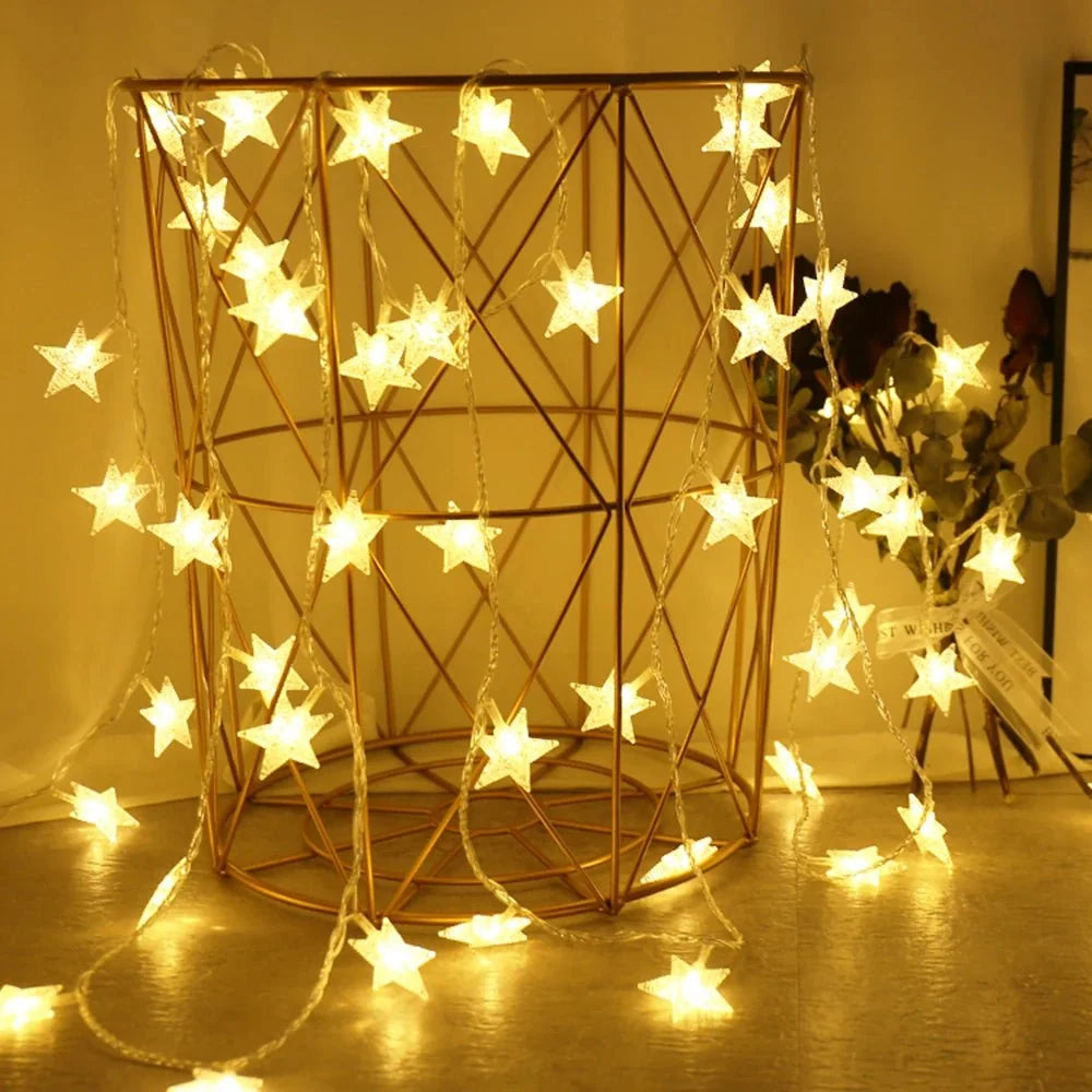 Star-shaped string lights draped over a geometric metal frame with a warm glow.