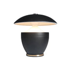 Black table lamp with a round base and flat top on a white background