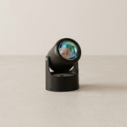 Black decorative object with a reflective surface on a beige background
