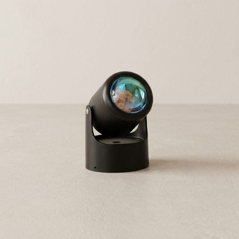 Black decorative object with a reflective surface on a beige background