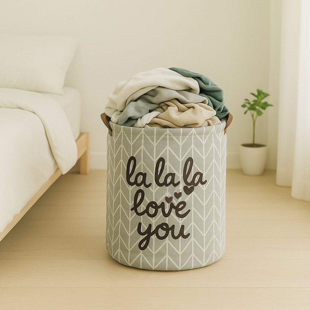 Laundry basket with clothes inside, placed on a wooden floor in a room.