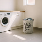 Laundry basket with clothes next to a washing machine in a laundry room.