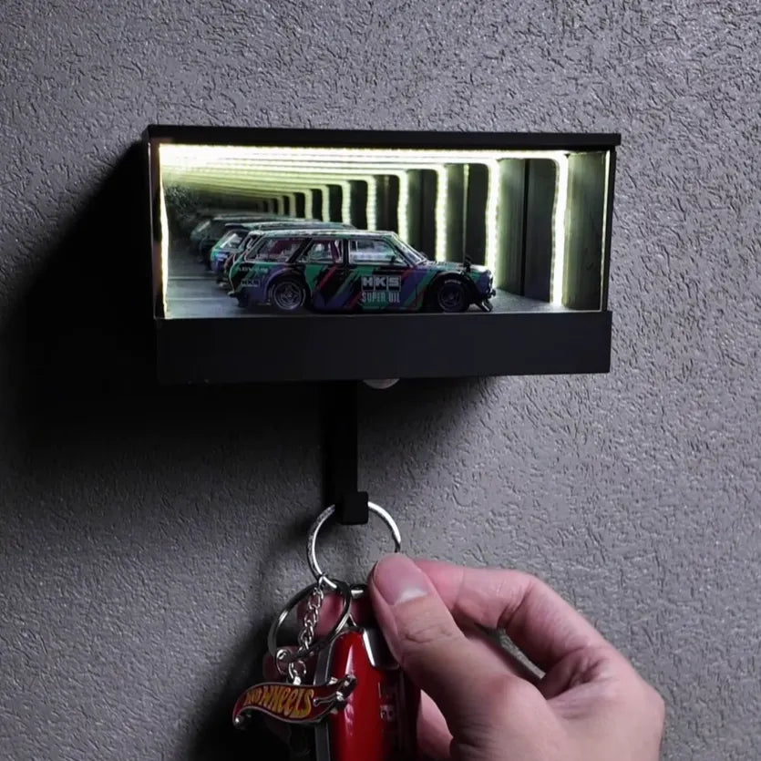 Key holder with a small mirror displaying a car image on a gray wall.