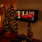 Small screen displaying images of red cars with a keychain hanging below, Christmas tree in the background.