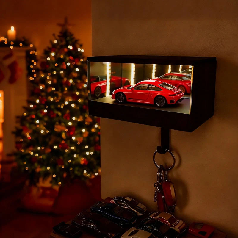 Small screen displaying images of red cars with a keychain hanging below, Christmas tree in the background.