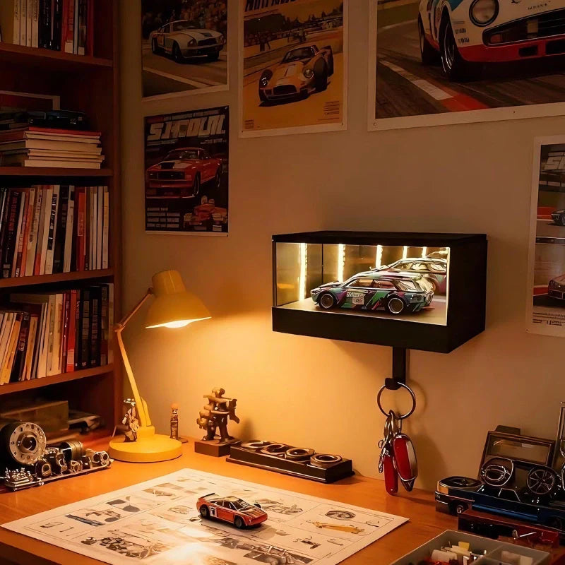 Desk with model cars, books, and a lamp in a room with car-themed decor.