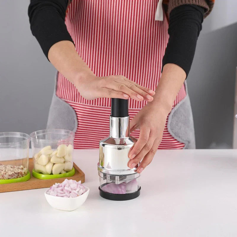 Person using a garlic press with ingredients on a kitchen counter