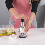 Person using a garlic press with ingredients on a kitchen counter