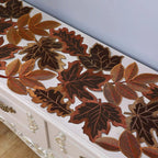 Decorative leaf-patterned table runner on a white surface