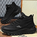 Black sneakers with 'EGMT Fashion' branding on a wooden floor.