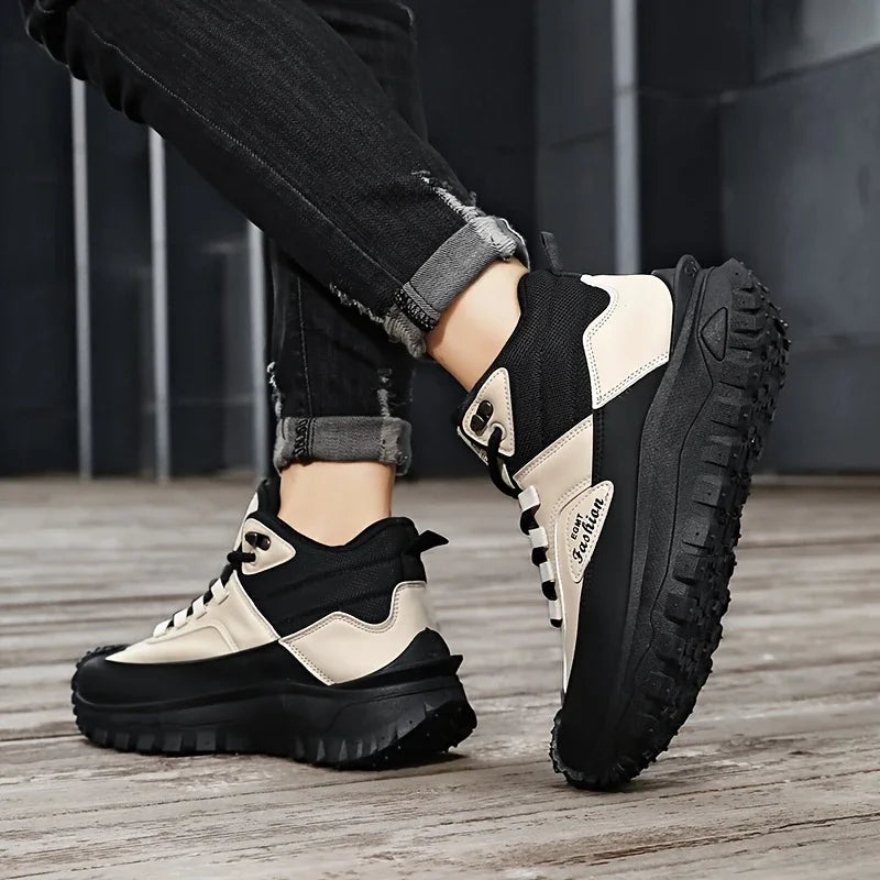 Black and beige sneakers worn with rolled-up jeans on a wooden floor.