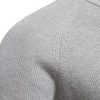 Close-up of a gray sweater sleeve with ribbed texture.