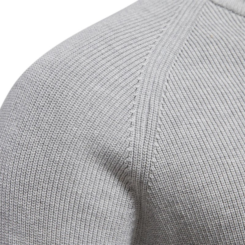 Close-up of a gray sweater sleeve with ribbed texture.
