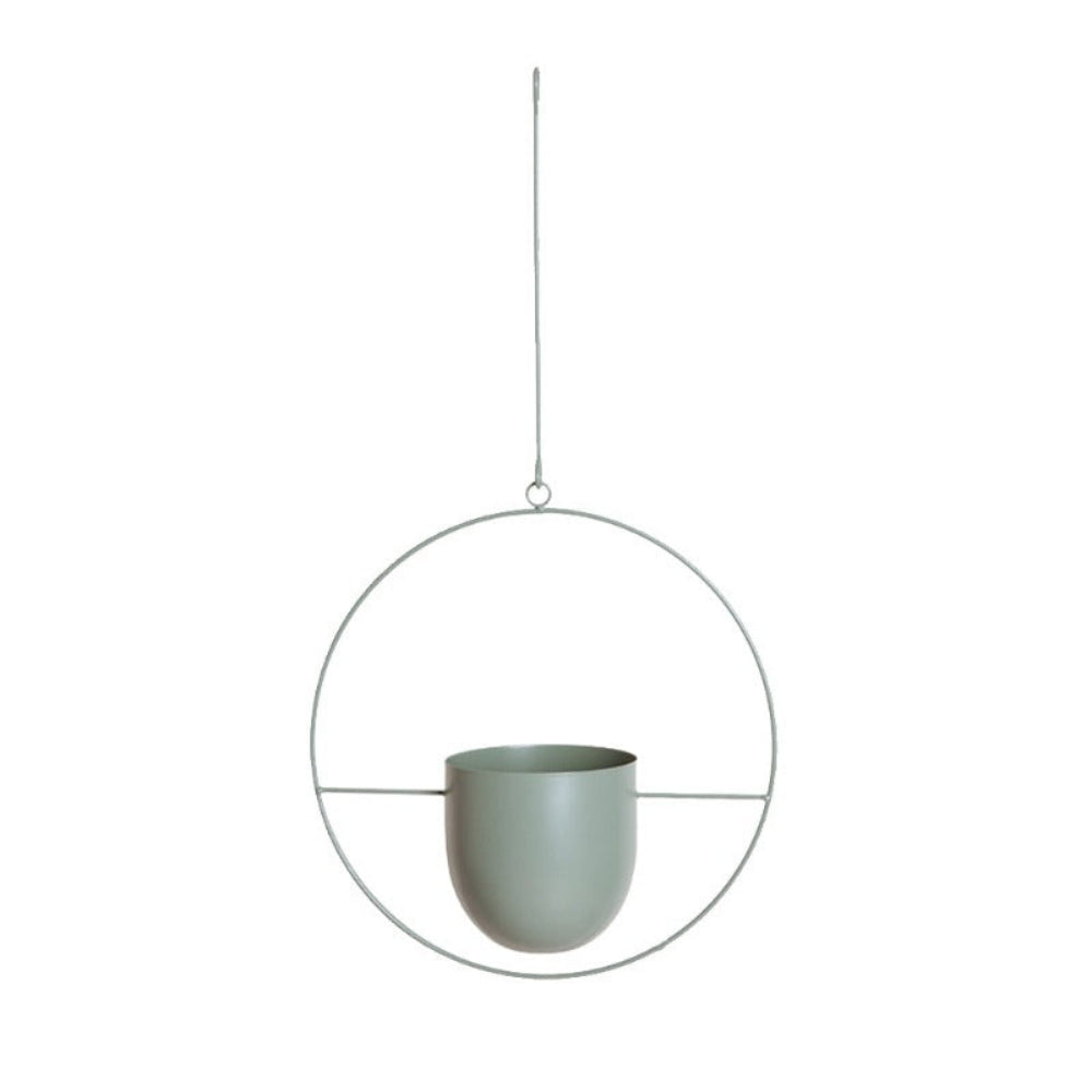 A minimalist hanging planter with a matte sage green ceramic pot suspended inside a thin circular metal frame on a solid white background.