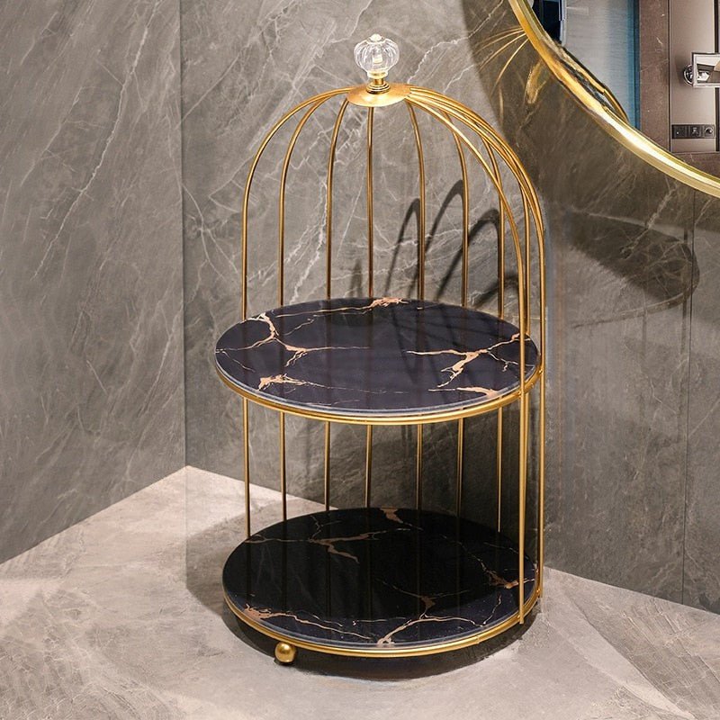 Decorative round table with gold frame and black marble top on a gray marble floor.