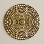 Decorative gold circular plate with intricate patterns on a beige background