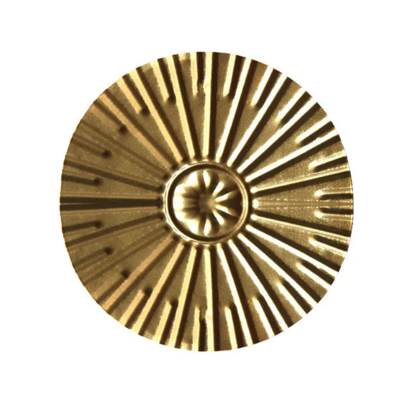 Gold decorative element with sunburst pattern on a white background
