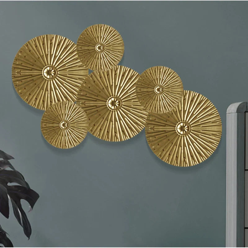 Set of gold circular wall decorations on a gray wall.
