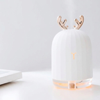 White lamp with gold antlers on a light gray background