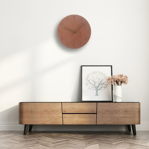 Wooden entertainment console with clock, framed picture, and flowers on a white wall.