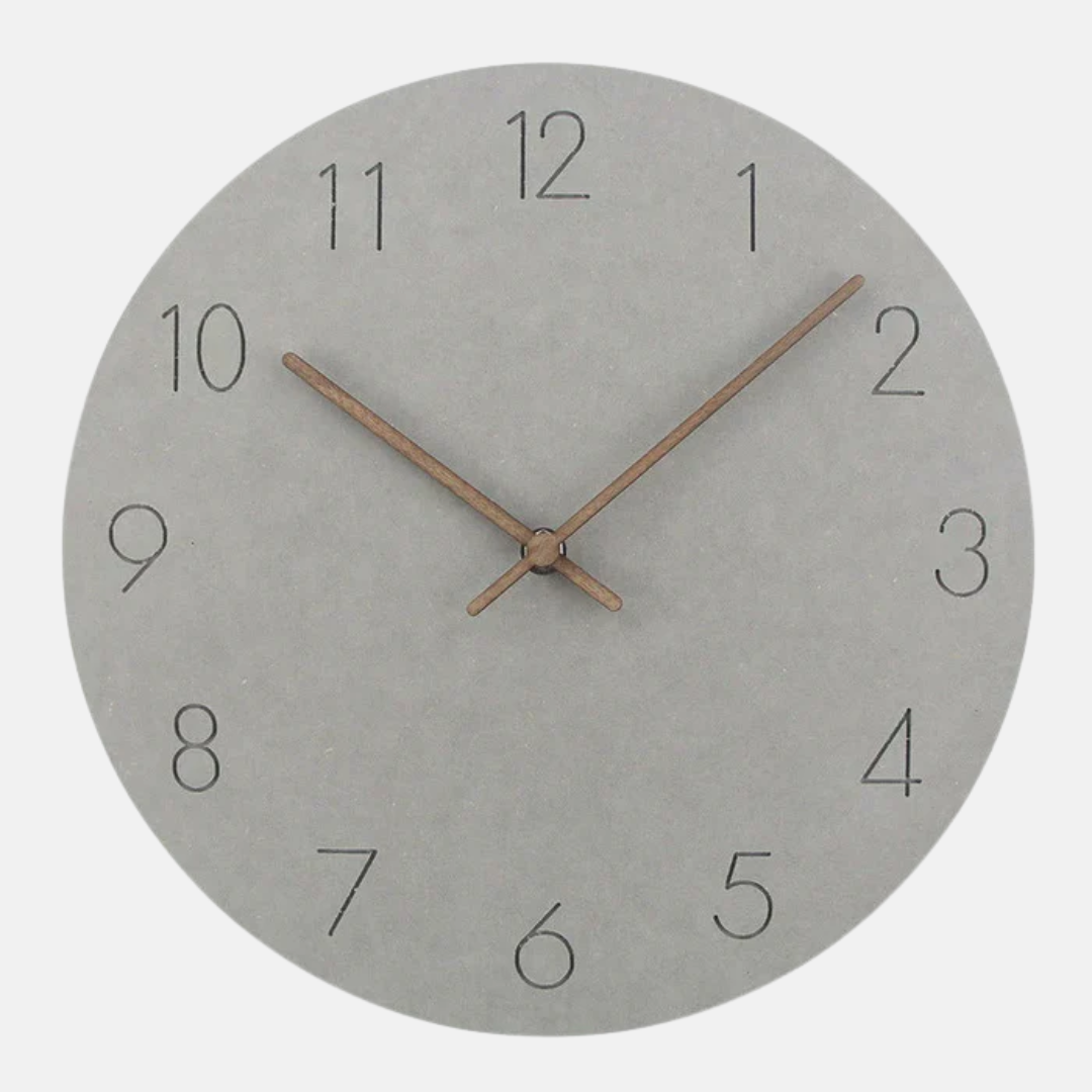 Round wall clock with concrete-like finish and bronze hands on a white background