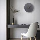 Modern interior with a desk, chair, and decorative elements on a light gray wall.