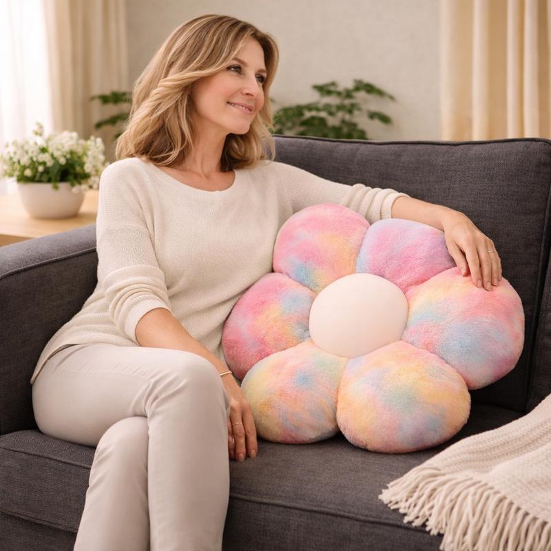 Woman sitting on a couch with a colorful flower-shaped pillow