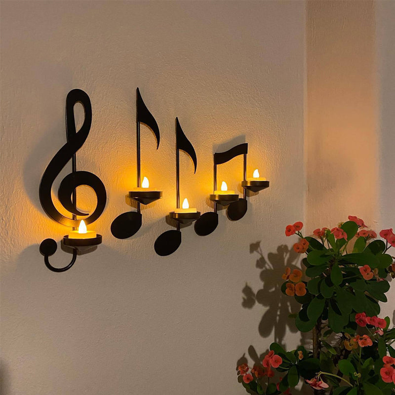 Decorative wall sconce with musical note designs on a wall with a plant in the corner.