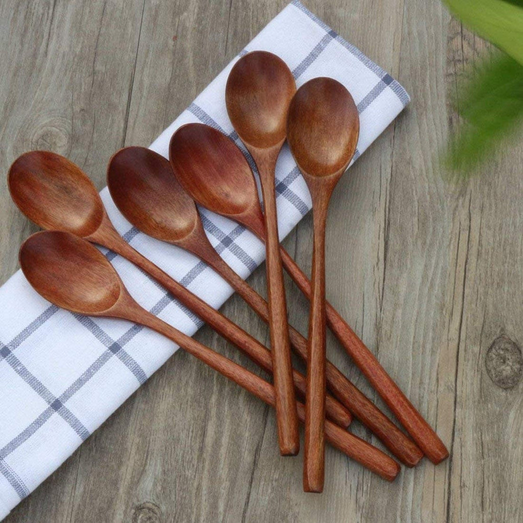 Set of wooden spoons on a checkered cloth with a wooden surface background