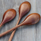 Three wooden spoons on a wooden surface