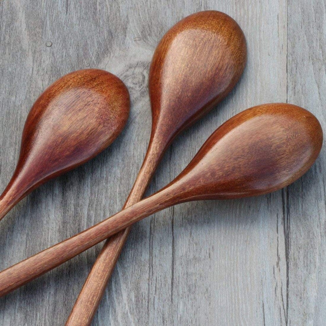 Three wooden spoons on a wooden surface