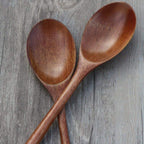 Two wooden spoons on a wooden surface