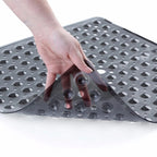 Hand pressing down on a textured gray mat with holes