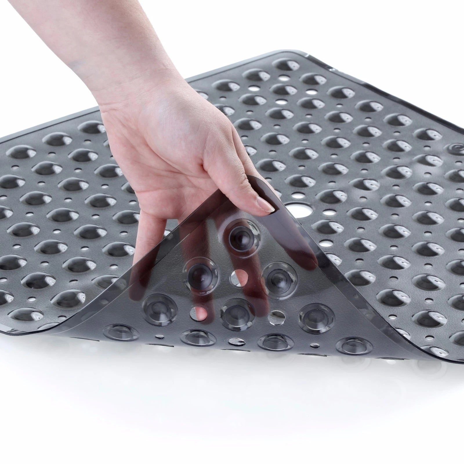 Hand pressing down on a textured gray mat with holes